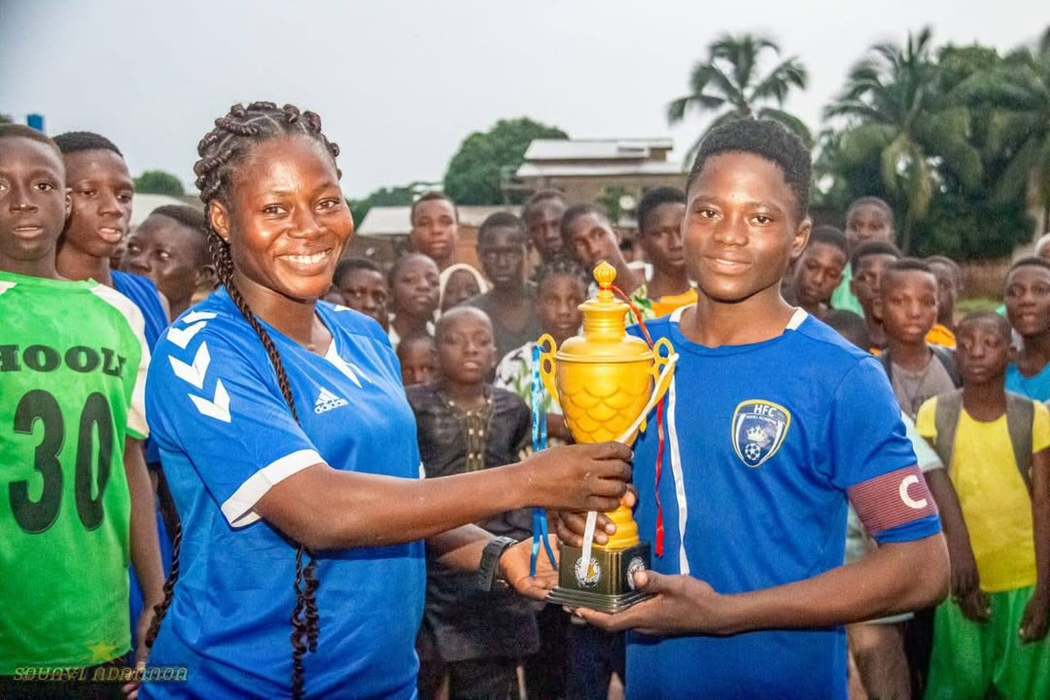 La capitaine de Hooli Académie reçoit un trophée des mains d'une encadrante.