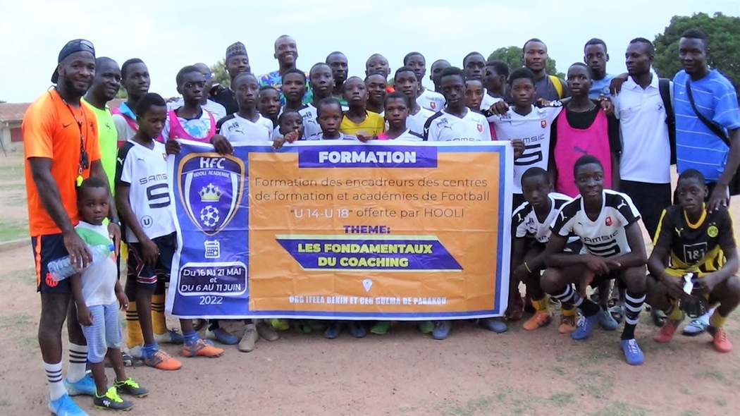 Participants et jeunes joueurs posant avec la banderole de la formation Hooli Académie.